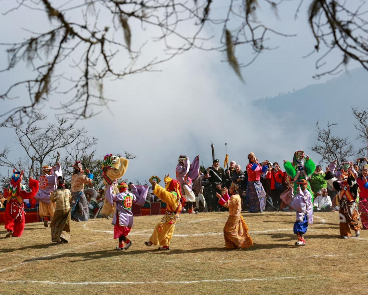 Masked cham dancers in elaborate costumes at tshechu